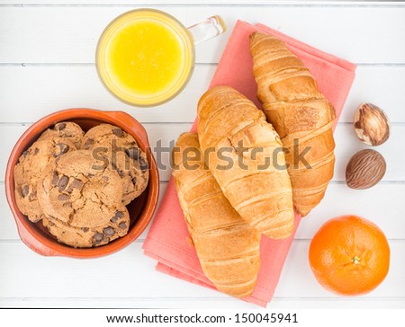 Croissant, cookies ,juice, fruit and chocolate