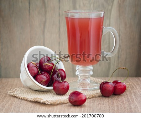 Cherries on wooden table and cherry juice