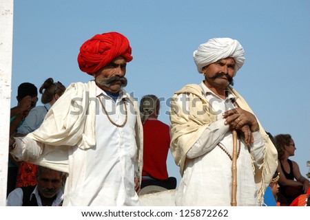 PUSHKAR, RAJASTHAN,INDIA - NOVEMBER 21: Unidentified Two Rajasthani tribal men wearing traditional  turbans attend the annual Pushkar Cattle Fair on November 21,2012 in Pushkar, Rajasthan, India