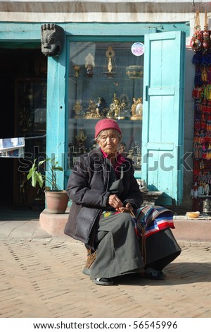KATHMANDU,NEPAL - DEC 29 : Old Tibetan woman-refugee near Swayambhunath stupa December 29, 2007 in Kathmandu. It\'s a place where Tibetan refugees live in Kathmandu.