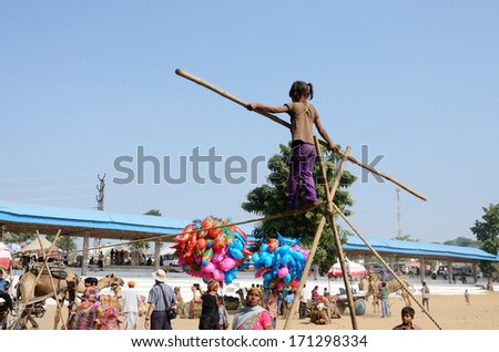 PUSHKAR, INDIA - NOVEMBER 12:Unidentified rope-walker are preparing to circus perfomance in nomadic camp during traditional camel fair holiday in Pushkar on November 12,2013 in Pushkar,Rajasthan,India
