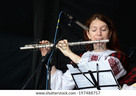 KIEV,UKRAINE - MAY 31:Unidentified woman playing the flute celtic medieval music in traditional scottish clothes during Day of Kiev holiday on May 31,2014 in Kiev,Ukraine