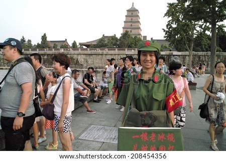 On July 31, 2014, in China, xi \'an wild goose pagoda scenic area, dressed in a red guards, selling old Popsicle work-study programs of the female college students to the tourists.