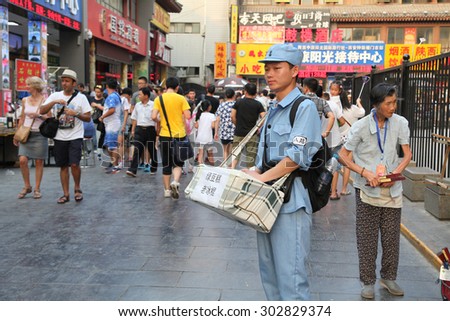 China. On July 29, 2015, xi \'an drum and hui street, in a special uniform of college students is to visitors from all over the world to sell old Popsicle. He is a work-study programs.