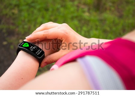Sporty woman using smart watch. Interface on watch screen was generated in graphical program