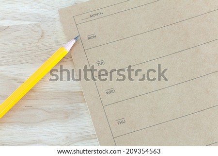 note book and pencil on wooden table