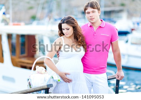Pregnant woman with her husband near the yacht