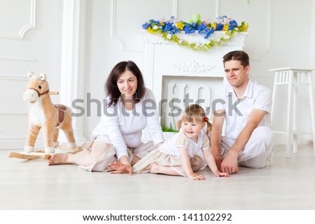 Happy family playing on the floor near the fireplace