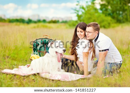 Happy couple with a dog having fun outdoors outside the city