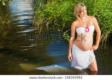Pregnant woman resting on the river. Swim in the lake. Safe Water activities.