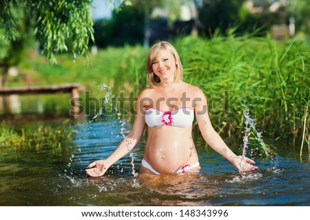 Pregnant woman resting on the river. Swim in the lake. Safe Water activities.