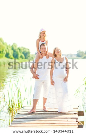 Happy young family fishing on the lake
