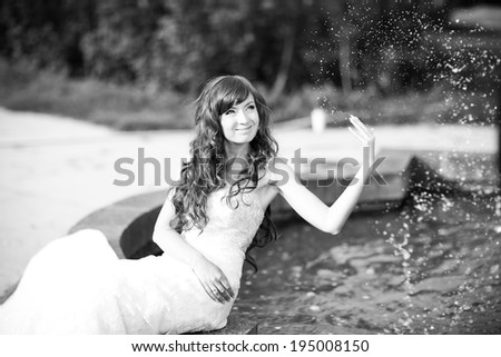 Beautiful bride sitting by the fountain