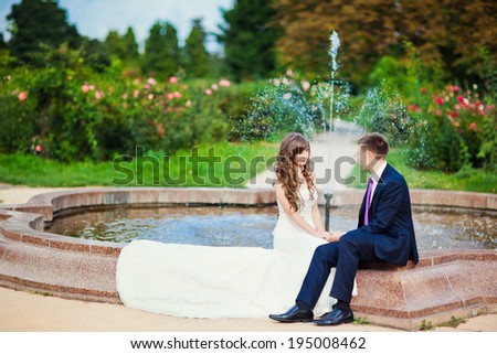 Wedding. Beautiful bride groom sitting at the fountain