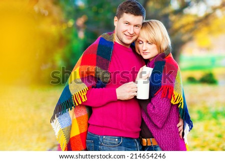 Young beautiful couple in the autumn park. Tea party on the nature. Autumn landscape. Love. Relationship. Love as a way out of the autumn depression.
