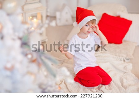 Santa\'s Little Helper, sleepy boy rubs his eyes. Fireplace, Christmas Eve. The kids go to sleep.