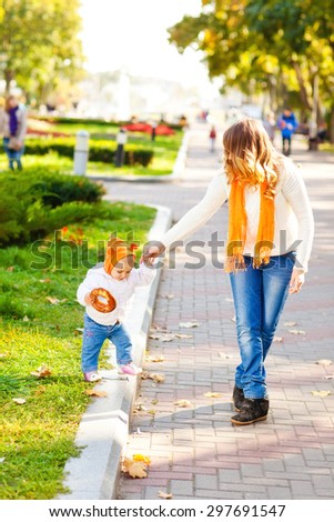 Woman with child in autumn park. Happy family. A young mother and her baby fall fun. walk in the park