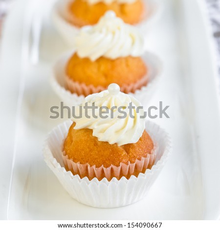 mini cupcakes decorated with white frosting and little pearls. Selective focus