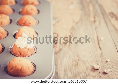 Vintage background with little cupcakes in baking pan. Selective focus