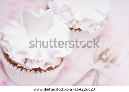 Beautiful cupcakes for wedding or little ballerina. Decorated with sugarpaste dress. Selective focus