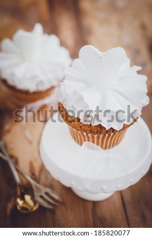 Beautiful cupcakes for wedding or little ballerina. Decorated with white sugar paste dresses. Selective focus
