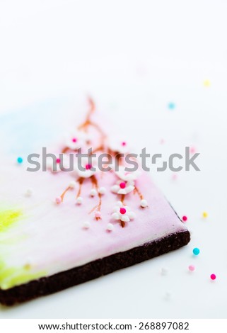 Close up of a beautiful cookie decorated with royal icing and sugar paste flowers. Selective focus.