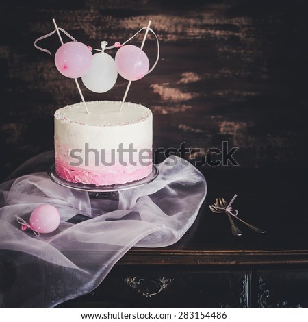 beautiful birthday / wedding cake with cream cheese frosting. On vintage table. Decorated with tiny balloons. Selective focus.