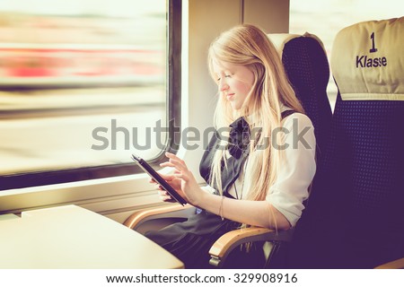 blond girl traveling in first class of a german train, toned image, selective focus