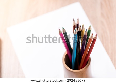 coloured pencil and paper note on wood table