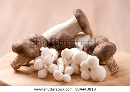 King oyster mushroom and shimeji mushroom and Shitake mushroom on chopping block ,wood table