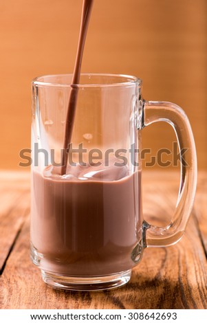 chocolate in glass pouring from top on wood table