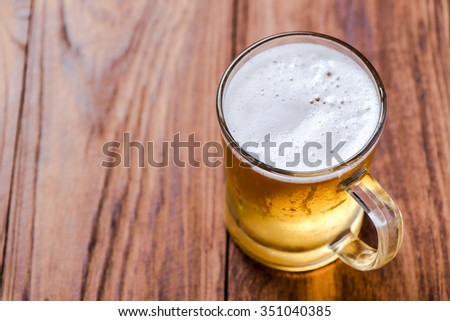 Beer in mug glass on wood table