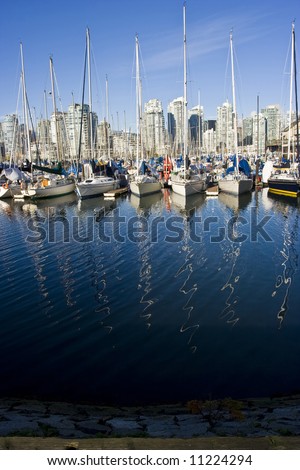 Sailboats in a vancouver marina with reflections of the masts in the ocean water