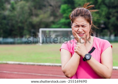 Portrait of female runner with toothache