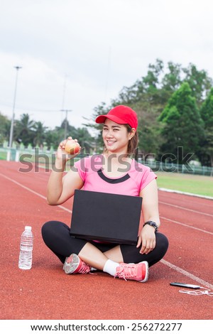 female runner  show apple on the running track and laptop