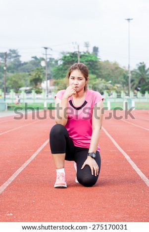 female runner sitting  on the running track