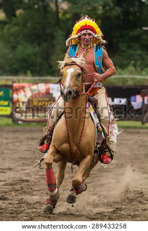 Barglowka, Poland - September 26, 2012: A man dressed as Indian chief with head-dress rides a horse during an event in Barglowka, Poland