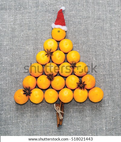 New year and Christmas card. Holiday and celebration concept. Christmas tree of tangerines in Santa hat.