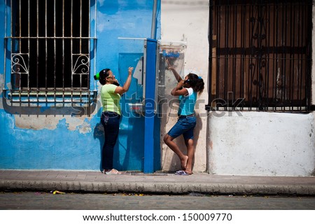 CAMAGUEY, CUBA - MARCH 12: Unidentified women talk on public telephones on the street on March 12, 2011 in Camaguey, Cuba. Telecommunication is very undeveloped in the socialist country.