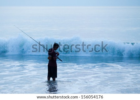 BALI - MARCH 11: Balinese man goes fishing on the beach on March 11, 2012 in Jimbaran beach Bali.