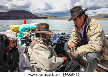 PUNO PERU - JANUARY 18: Unidentified local man travel on top of a motor boat on the Lake Titicaca in Peru on January 18, 2010.