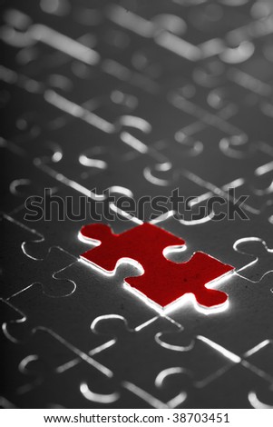 black puzzle with one red piece