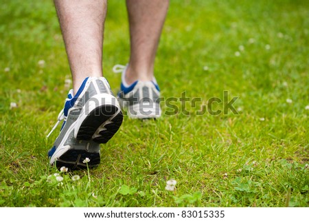 legs of walking man on grass