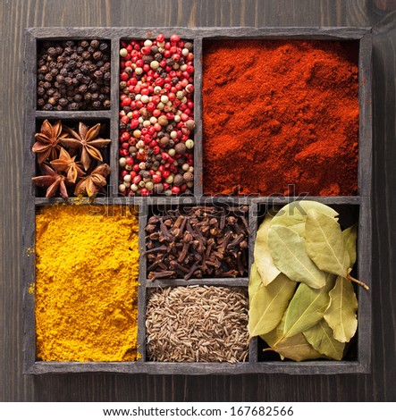 spices in box: pink and black pepper, paprika powder, curry, bay leaf; anise; clove; cumin