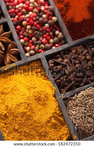 spices in box: pink and black pepper, ground paprika, curry, anise; clove; cumin