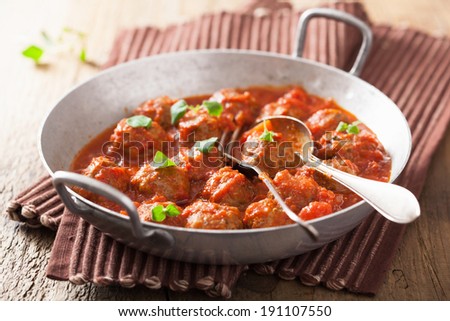 meatballs with tomato sauce in pan with spoon