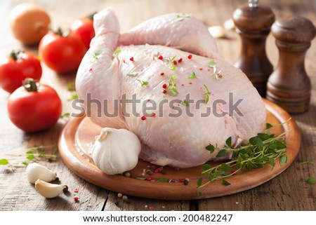 whole raw chicken with rose pepper and thyme