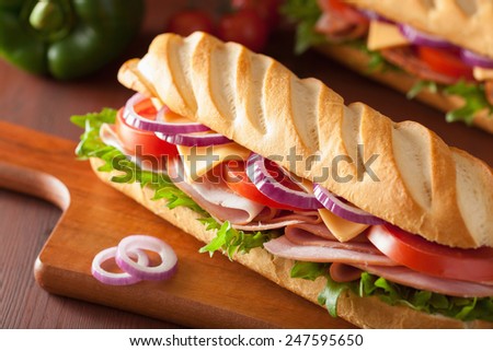long baguette sandwich with ham cheese tomato and lettuce