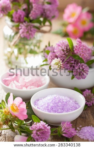 spa with pink herbal salt and wild rose flowers clover