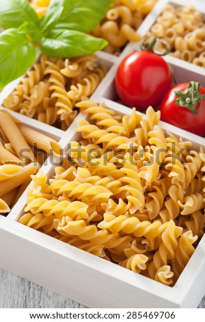 various raw wholegrain pasta in white wooden box
